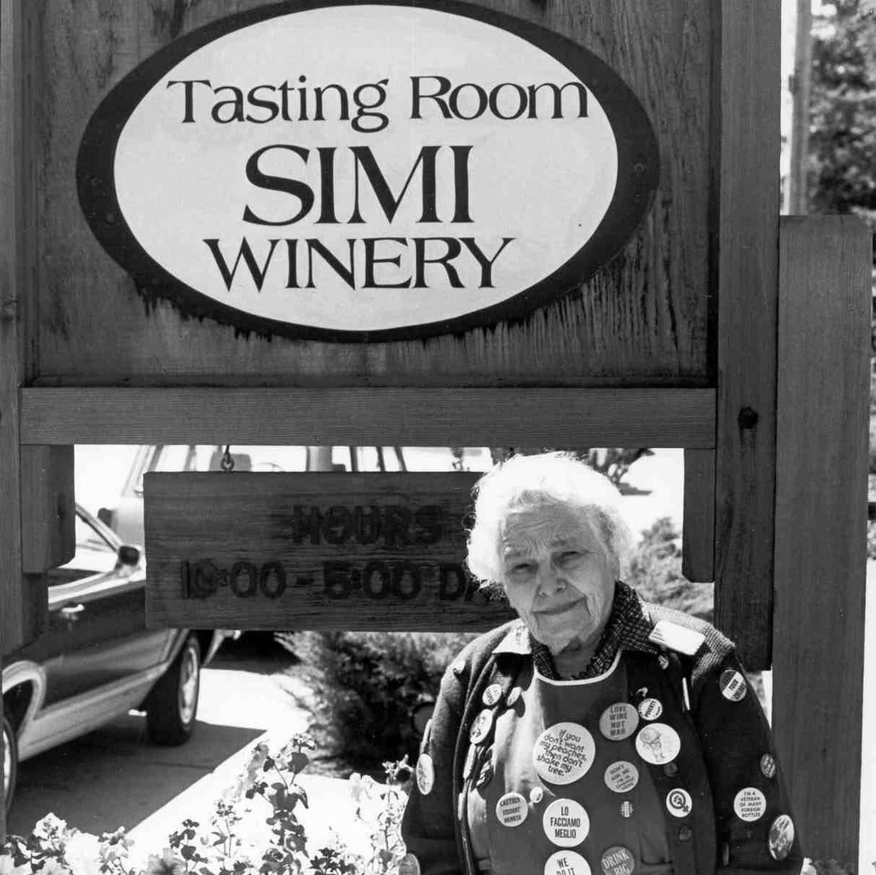 Image of Isabelle Simi in front of the SIMI Winery Tasting Room sign in black and white.