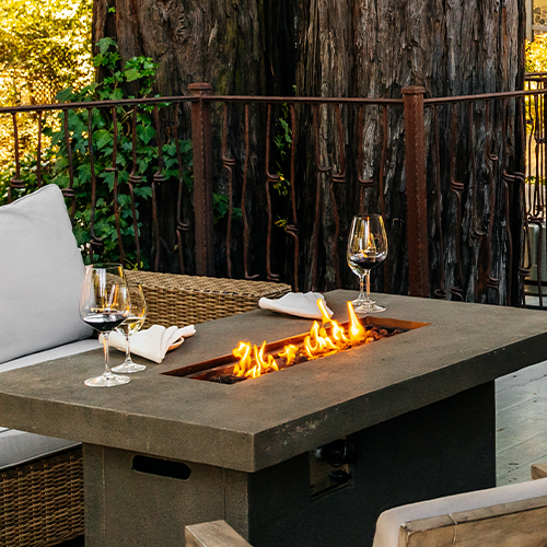 Wine glasses full of SIMI wines surround an outside firepit on the SIMI Winery deck.