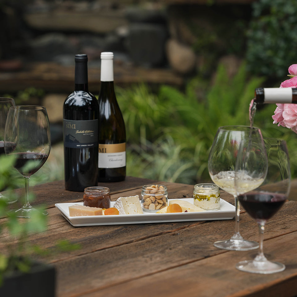 A wine glass of SIMI Chardonnay and SIMI Cabernet Sauvignon are on the SIMI Winery's patio.